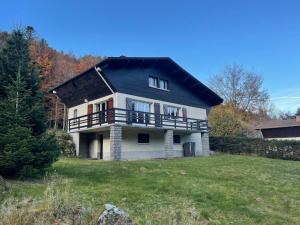 ラ・ブレスにあるCHALET DES HAUTS SAPINS LA BRESSEの黒屋根の大白い家