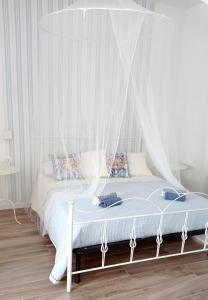 białe łóżko z baldachimem w sypialni w obiekcie IL GUFO DELLA MARZA w mieście Ispica