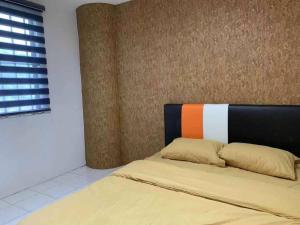 1 dormitorio con 1 cama con cabecero naranja y blanco en Pangkor Island CoralBay Private Apartment en Pasir Bogak