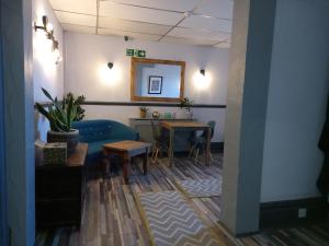 une salle d'attente avec un canapé bleu et une table dans l'établissement Vinnie's Family Hotel, à Blackpool