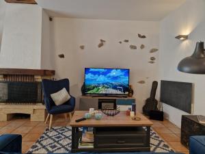 - un salon avec une télévision et une chaise bleue dans l'établissement Countryhouse close to Senlis and Parc Asterix, à Thiers-sur-Thève