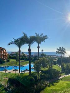 - une vue sur la piscine bordée de palmiers dans l'établissement Los Granados de la Duquesa, à San Luis de Sabinillas