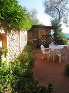 a patio with a table and chairs on a patio at Onda Su Onda Appartamenti in Seccheto