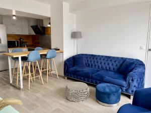 sala de estar con sofá azul y mesa en La Marina - Proche Paris & Aéroport CDG, en Sevran