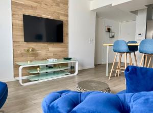 sala de estar con sofá azul y TV en La Marina - Proche Paris & Aéroport CDG, en Sevran
