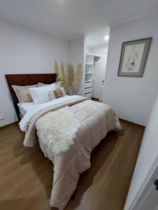 a bedroom with a large bed with a white blanket at Departamento Exclusivo clase A in Lima
