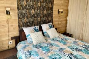 a bed with blue and white sheets and pillows at Le Nautica - Proche CDG - 4 Prs - Balcon in Sevran