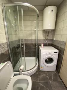 uma casa de banho com um WC e uma máquina de lavar roupa em Nikolina em Skopje