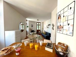 a kitchen and living room with a table with orange juice at Le Riquet - 4 people - Hyper Center - Metro in Toulouse