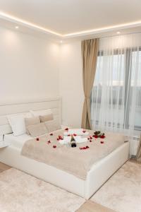 a white bedroom with a bed with roses on it at SINFONIA LUX in Belgrade