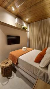 a bedroom with a large bed with a television on the wall at Cobertura Milagres do Chef in São Miguel dos Milagres