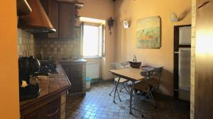 uma cozinha com uma mesa e cadeiras em Palazzo centro storico em Soriano nel Cimino