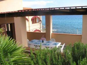 a table on the balcony of a house with the ocean at Onda Su Onda Appartamenti in Seccheto