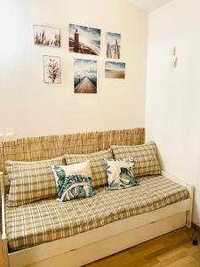 un canapé dans une pièce avec des photos sur le mur dans l'établissement Duplex 3 piscines (1 chauffée/couverte) 300m plage, à Les Sables Vignier