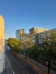 une route vide dans une ville avec de grands bâtiments dans l'établissement Apartment Schönbrunn near Metro, à Vienne