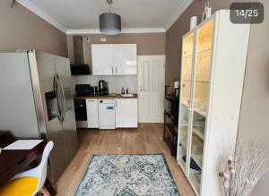 a kitchen with white cabinets and a refrigerator at See Schmetterling (Fjäril) in Wismar