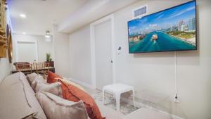 - un salon avec un canapé et une télévision murale dans l'établissement Modern Apartment in the Heart of Miami, à Miami