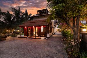 a resort with a building with red lights on it at Mayci Boutique Hotel Hoi An in Hoi An