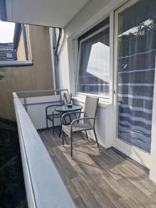 uma varanda com 2 cadeiras, uma mesa e uma janela em M&BLuxux Apartaments em Krefeld