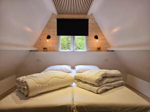 a bedroom with two beds in a room with a window at de bosdriehoek II in Durbuy