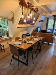 a dining room with a wooden table and chairs at de bosdriehoek II in Durbuy