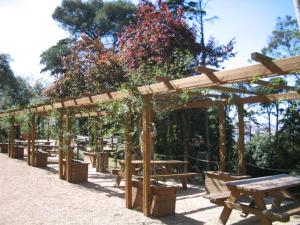 a wooden pergola with benches and a picnic table at Simpático apartamento no centro in Lisbon