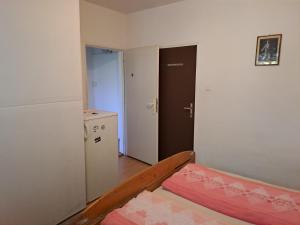 Habitación pequeña con cama y nevera. en Apartmán na Jižní en Olomouc