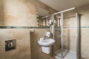 ein Badezimmer mit Waschbecken und Dusche in der Unterkunft Hotel Muza in Košice + 161 Fotos