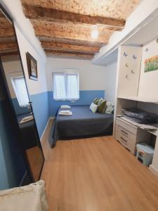 mały pokój z łóżkiem i drewnianą podłogą w obiekcie Habitaciones Casa Santander Playa Valdenoja w mieście Santander