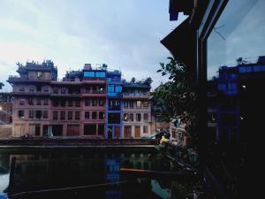 un groupe de bâtiments à côté d'une masse d'eau dans l'établissement Hostel Swastik, à Bhaktapur