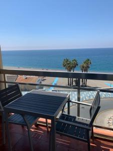 una mesa y sillas en un balcón con vistas al océano en Apartamentos Chinasolymar, en Almuñécar