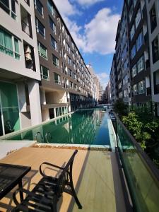 a balcony with a table and a bench next to some buildings at Bangkok Sathon RYE condo in Bangkok