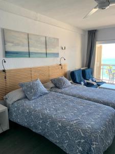 アルムニェーカルにあるApartamentos Chinasolymarのベッドルーム1室(ベッド2台付)が備わり、海の景色を望めます。