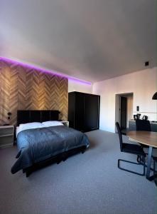 Schlafzimmer mit einem Bett mit violetten Lichtern an der Wand in der Unterkunft Gamler Apartments by Letrent in Żyrardów