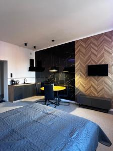 a bedroom with a bed and a table and a kitchen at Gamler Apartments by Letrent in Żyrardów