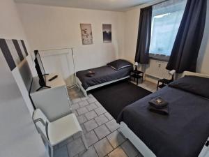 um pequeno quarto com 2 camas e um sofá em Bright & Cozy Apartment em Plettenberg