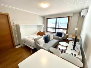 sala de estar con sofá y mesa en Estudio céntrico 2 con terraza y parking privado en Ourense