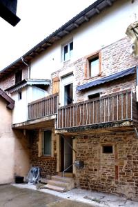 un antico edificio in mattoni con balcone e scale di Le Contemporain*WIFI*Central a Saint-Laurent-sur-Saône