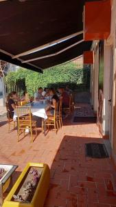 un grupo de personas sentadas en una mesa en un patio en Hotel Peja, en Peje