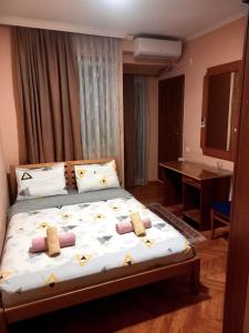 um quarto com uma cama grande com almofadas em Hotel Peja em Pec