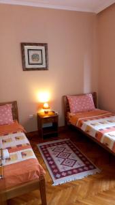 a bedroom with two beds and a table with a lamp at Hotel Peja in Peje