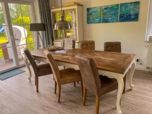 a dining room with a wooden table and chairs at Haus Sansibar auf Poel mit Sauna& Kamin, ruhigem Garten-700m vom Strand! in Insel Poel