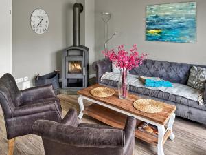 a living room with a couch and a table with a fireplace at Haus Sansibar auf Poel mit Sauna& Kamin, ruhiger Garten-700m vom Strand! in Insel Poel