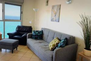 a living room with a couch and a chair at Star Way in Bat Yam +3 photos