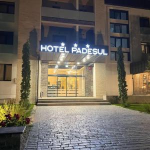 un hotel con un cartel en la parte delantera de un edificio en Hotel Padesul, en Făget