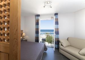 a bedroom with a bed and a view of the ocean at Hotel St Joseph in Algajola