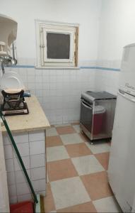 a kitchen with a tile floor with a stove and a window at Agami Guest House in Alexandria