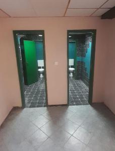 a bathroom with three urinals and three sinks in a room at Hostel UNDERGROUND in Maribor