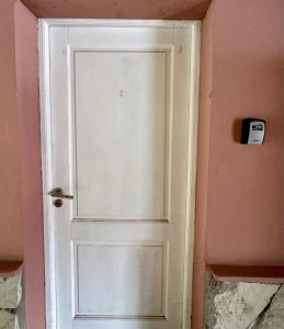 uma porta branca num quarto cor-de-rosa em Casita Silvestre y Casa Rosa em Villa La Angostura