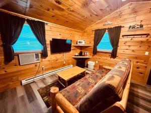 a living room with a couch in a log cabin at Willow Cabin in Thompsonville